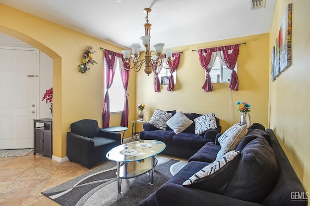 tiled living area featuring a chandelier, arched walkways, visible vents, and baseboards