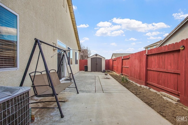 view of patio with a fenced backyard, a storage unit, an outdoor structure, and central air condition unit