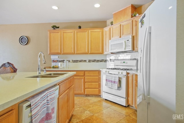 kitchen with light countertops, backsplash, light brown cabinets, a sink, and white appliances