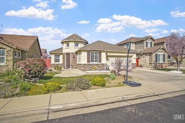 view of front of property featuring a garage, a tile roof, stone siding, concrete driveway, and stucco siding