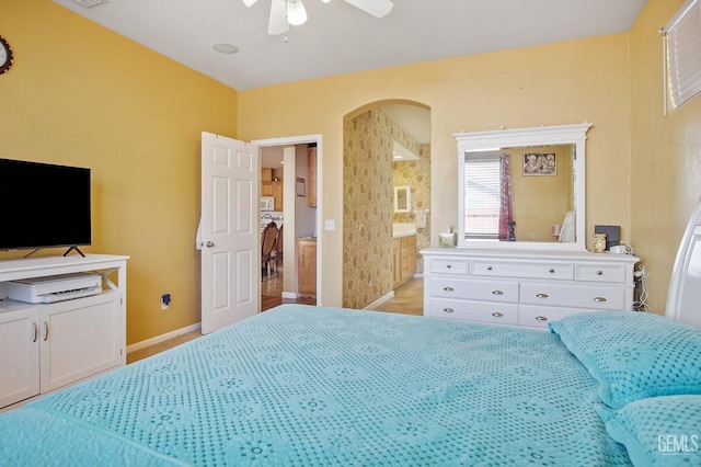 bedroom featuring baseboards, visible vents, arched walkways, and a ceiling fan