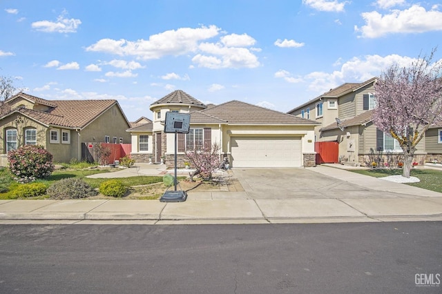 view of front of property featuring driveway, stone siding, an attached garage, and stucco siding