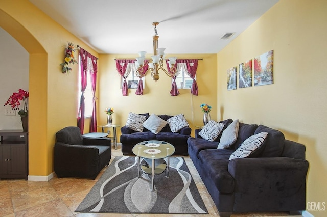 living room featuring arched walkways, visible vents, baseboards, and an inviting chandelier