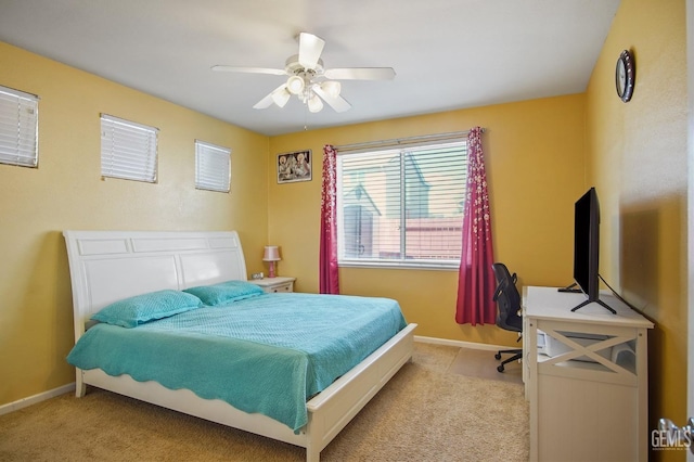 carpeted bedroom with ceiling fan and baseboards