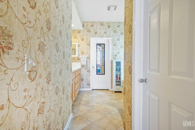 bathroom with tile patterned floors, vanity, visible vents, and wallpapered walls