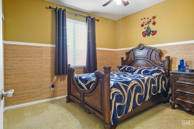 bedroom featuring ceiling fan, carpet floors, and a wainscoted wall