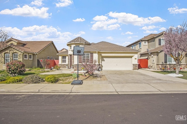 view of front facade with driveway, stone siding, a tiled roof, an attached garage, and stucco siding