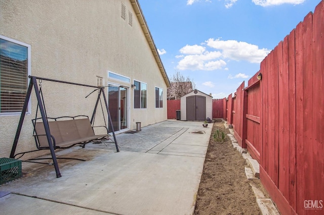 view of patio with an outbuilding, a fenced backyard, and a storage shed