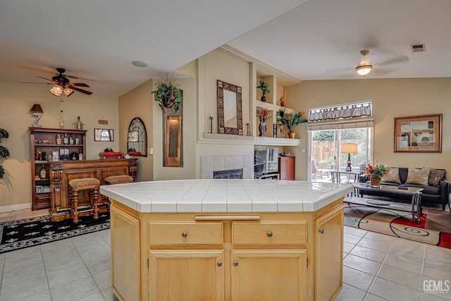 502 Lewisham St, Bakersfield, CA 93311 - kitchen featuring ceiling fan, tile countertops, light tile patterned floors, open floor plan, and vaulted ceiling