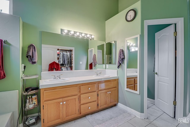 502 Lewisham St, Bakersfield, CA 93311 - bathroom featuring double vanity, tile patterned floors, a high ceiling, and a walk in closet