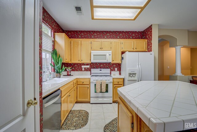 502 Lewisham St, Bakersfield, CA 93311 - kitchen featuring white appliances, tile countertops, a sink, and ornate columns
