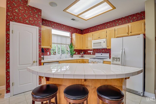 502 Lewisham St, Bakersfield, CA 93311 - kitchen with white appliances, wallpapered walls, light tile patterned floors, tile counters, and a sink