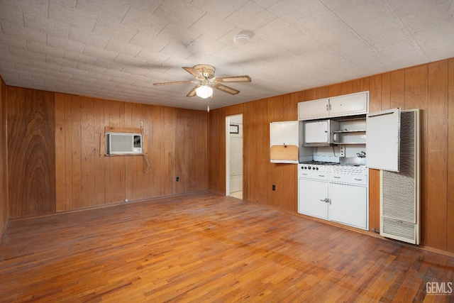 kitchen featuring ceiling fan, light wood-type flooring, white cabinetry, and an AC wall unit