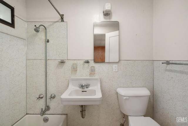 full bathroom with tiled shower / bath, toilet, tile walls, and sink