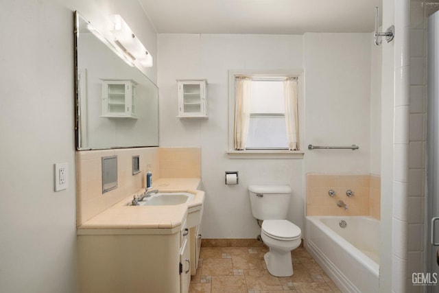 bathroom with vanity, toilet, and a tub to relax in