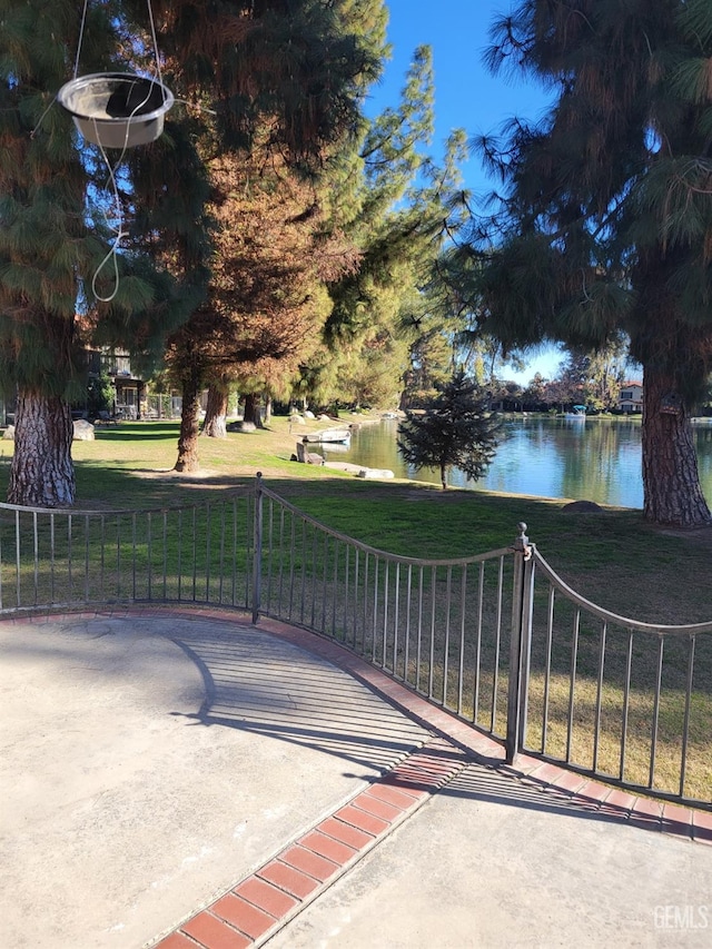 view of gate with a yard and a water view