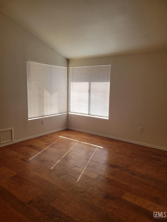 unfurnished room with vaulted ceiling and dark hardwood / wood-style floors