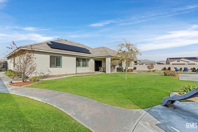 view of front of home featuring a front lawn and solar panels