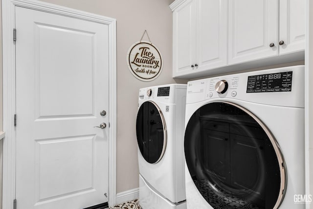 washroom with cabinets and washing machine and clothes dryer