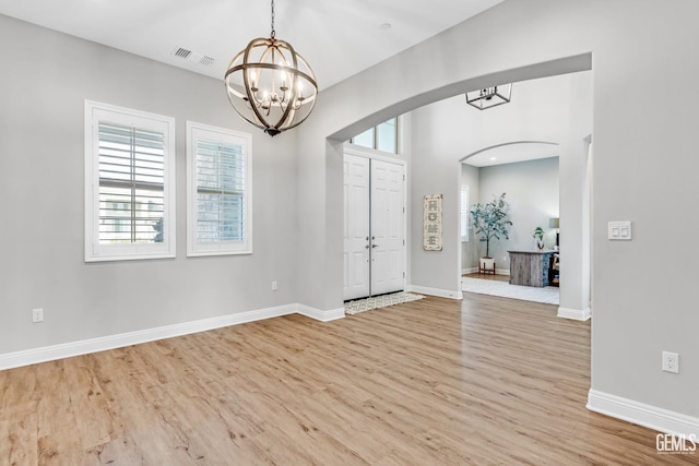 entrance foyer with light hardwood / wood-style floors and a notable chandelier