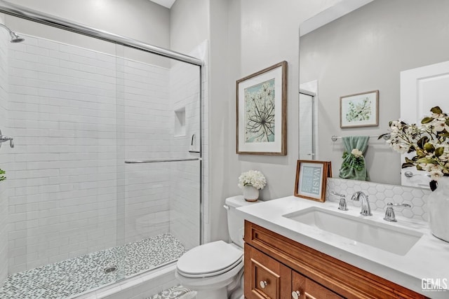 bathroom with an enclosed shower, vanity, and toilet