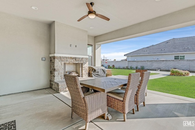 view of patio / terrace with an outdoor stone fireplace, grilling area, and ceiling fan