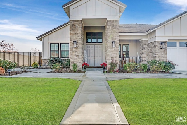 property entrance with a lawn, covered porch, and a garage