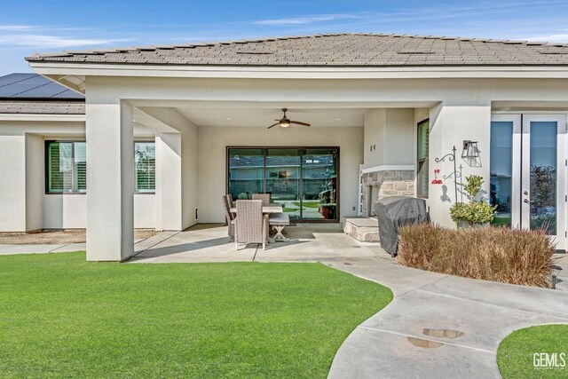 exterior space featuring a patio area, ceiling fan, a yard, and solar panels