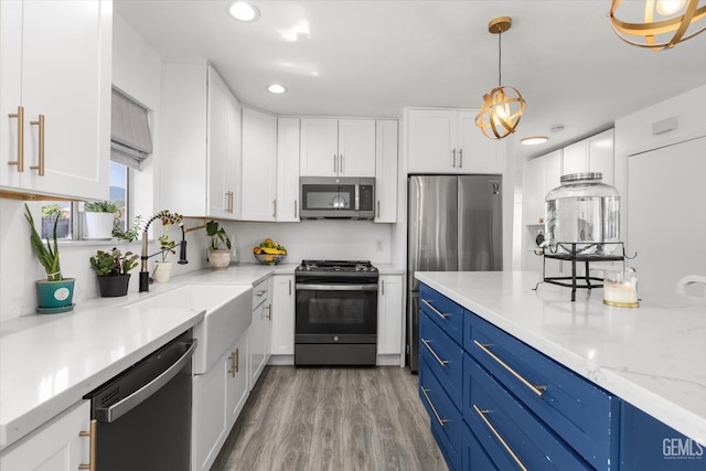 21633 Golden Hills Blvd, Tehachapi, CA 93561 - kitchen with stainless steel appliances, blue cabinetry, white cabinetry, recessed lighting, and light wood-style flooring