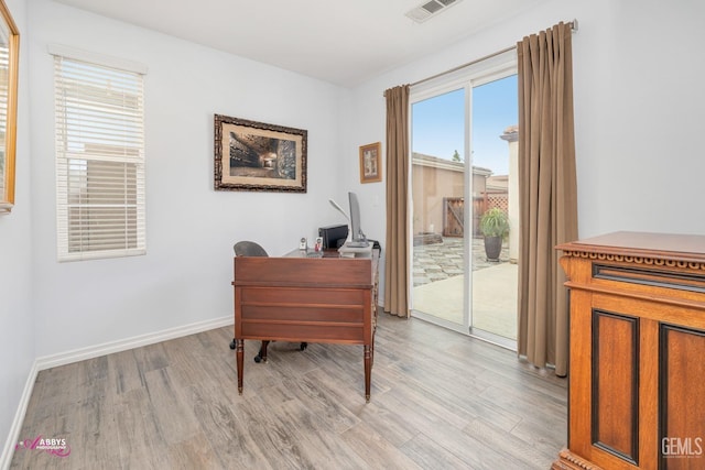 office space with a healthy amount of sunlight and light hardwood / wood-style floors