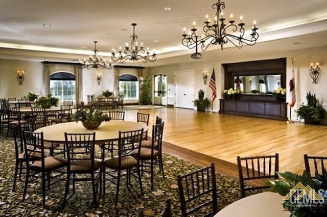 dining area with hardwood / wood-style floors and an inviting chandelier