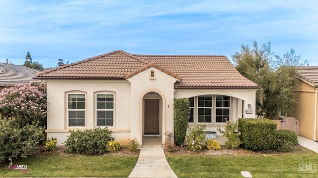 mediterranean / spanish-style house with a front lawn