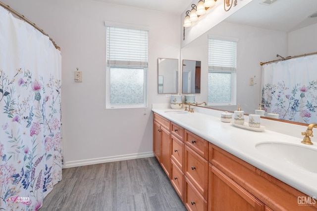 bathroom with vanity, curtained shower, and wood-type flooring