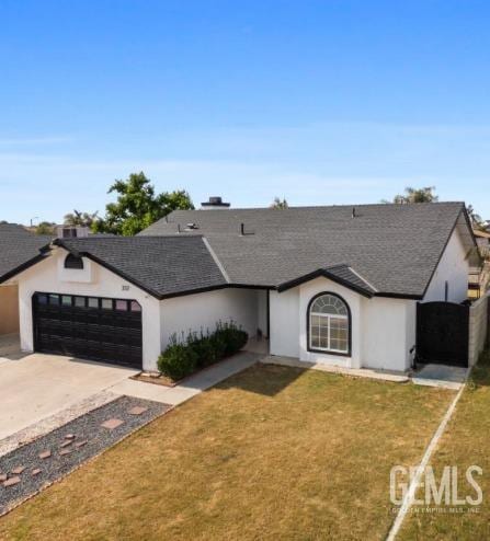 337 Cesar Chavez Ln, Delano, CA 93215 - single story home with an attached garage, driveway, a front lawn, stucco siding, and a shingled roof