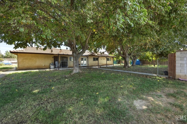 view of yard with french doors and fence