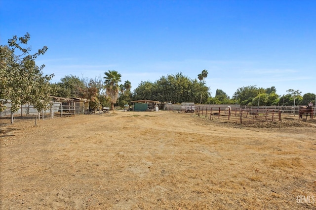 view of yard with a rural view, an outdoor structure, and an exterior structure