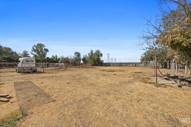 view of yard featuring fence and a rural view