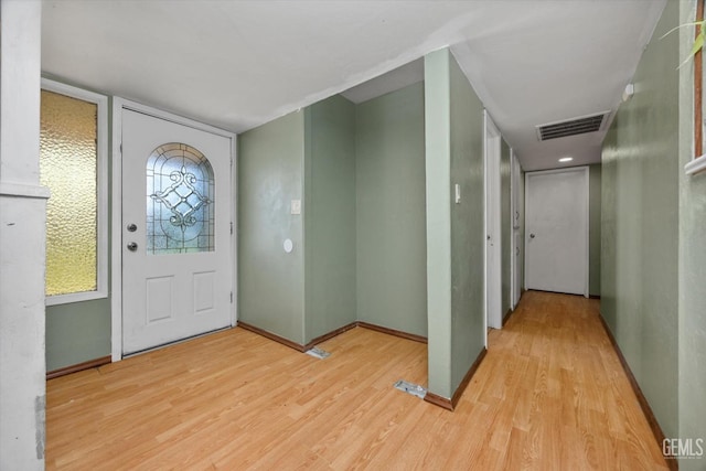 foyer entrance featuring light wood-style flooring, visible vents, and baseboards