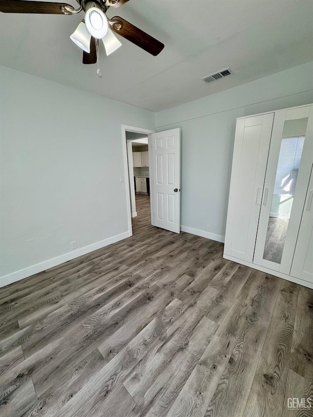 unfurnished bedroom with ceiling fan and hardwood / wood-style floors