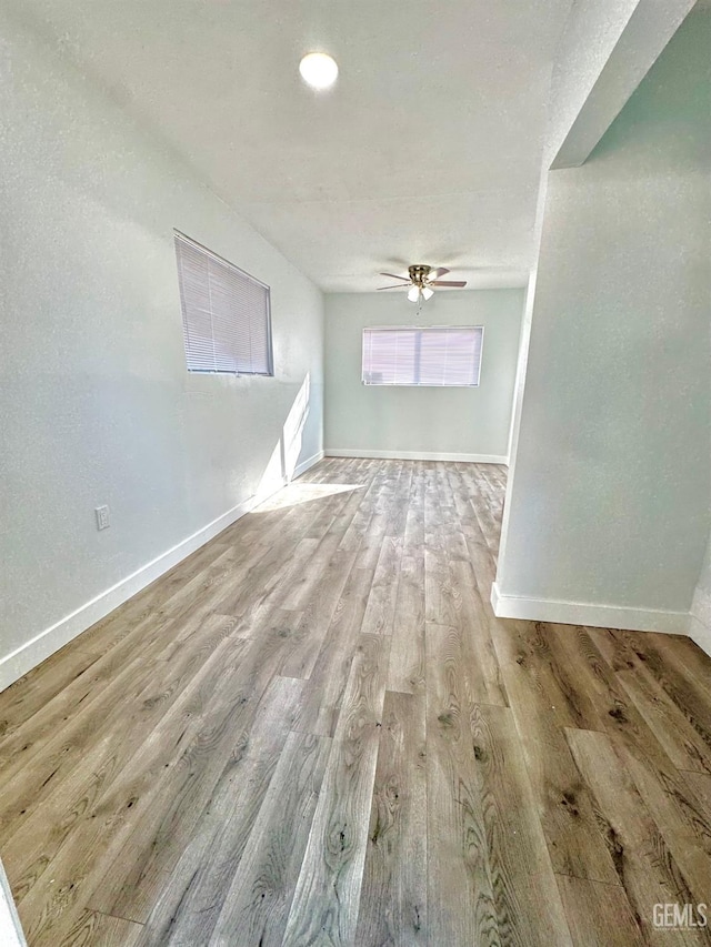 empty room with ceiling fan and light wood-type flooring