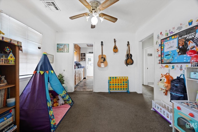 playroom featuring ceiling fan and dark carpet