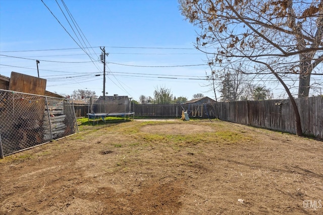 view of yard with a playground and a trampoline