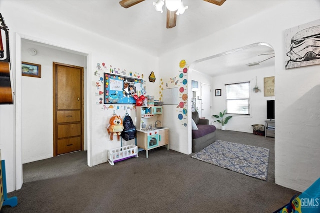 interior space featuring ceiling fan and dark carpet