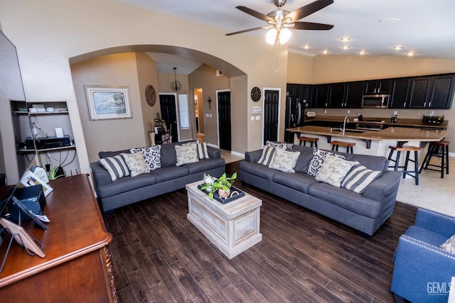 living room with lofted ceiling, ceiling fan, dark wood-type flooring, and sink