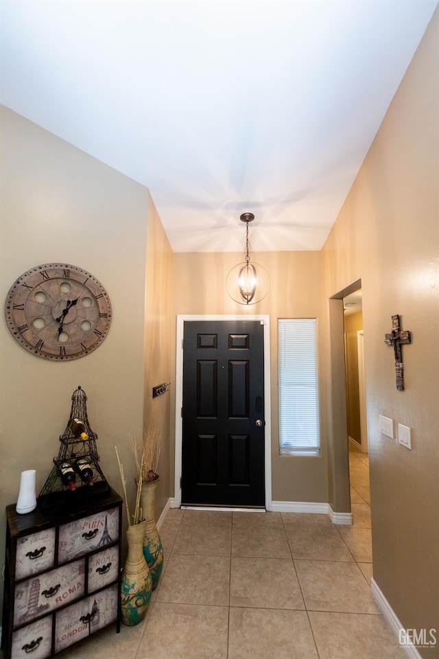 tiled foyer entrance with a chandelier