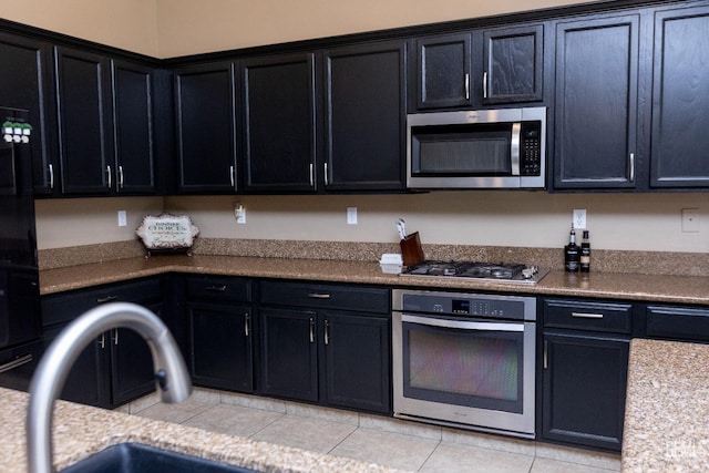 kitchen with sink, light tile patterned flooring, and appliances with stainless steel finishes