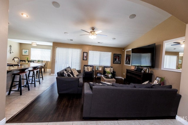 living room featuring light tile patterned floors, vaulted ceiling, ceiling fan, and sink