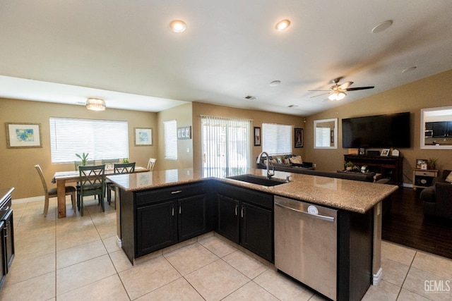 kitchen featuring dishwasher, sink, an island with sink, and vaulted ceiling