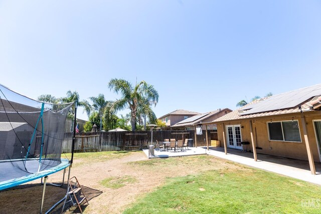 view of yard with a patio area, a trampoline, and french doors