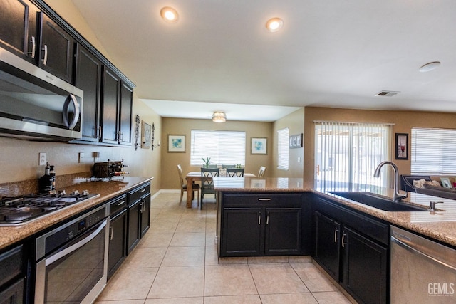 kitchen with light tile patterned floors, sink, and appliances with stainless steel finishes